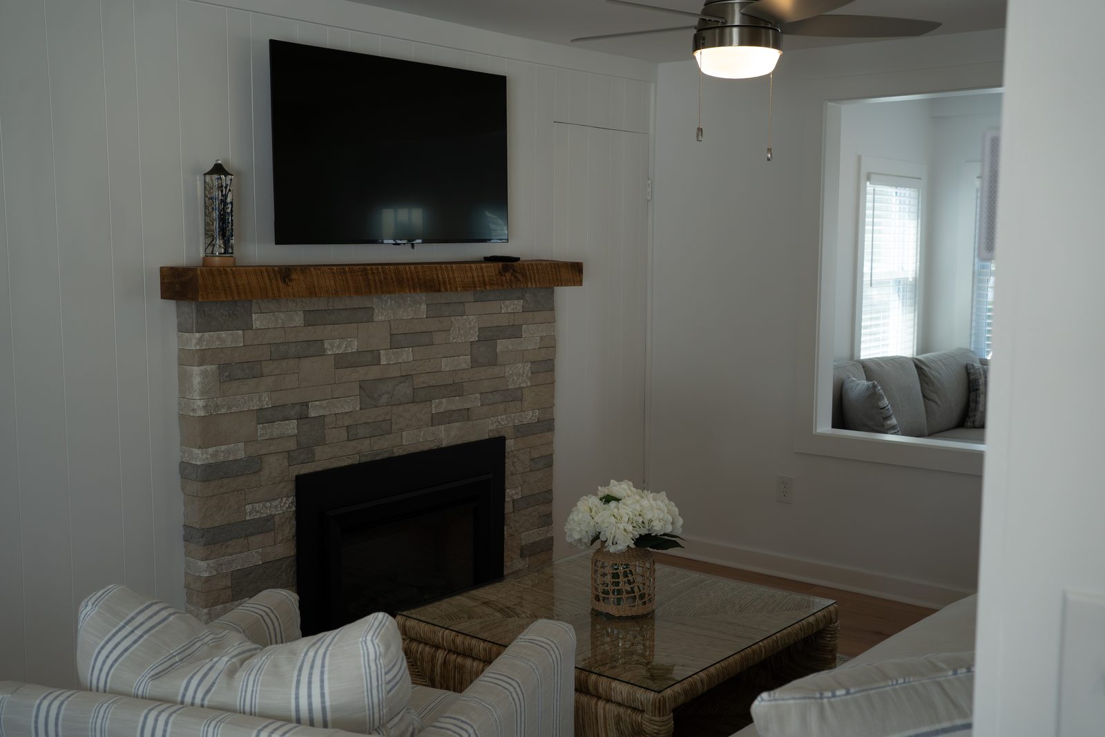 Stone fireplace with a reclaimed wood mantel and TV above